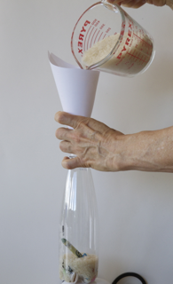 Pouring sand into the bottle.